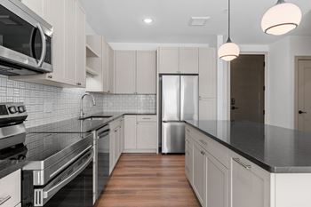 Kitchen with black counter tops and white cabinets